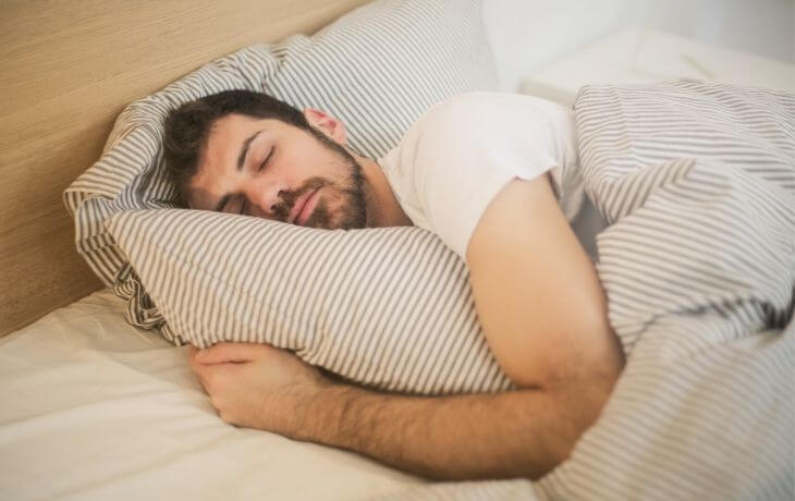 Importance du sommeil article de blog Homme dormant dans son lit